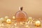 Unbranded round perfume bottle, gold christmas balls and paper firecracker pieces on golden background. Transparent glass perfume