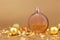 Unbranded round perfume bottle, gold christmas balls and paper firecracker pieces on golden background. Transparent glass perfume