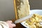 Uncapping honey cells with a fork. Professional beekeeper holds wooden frame with bee honeycomb in his hands, collects