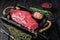 Unccoked rump steak or raw top sirloin beef meat steak. Black wooden background. Top view