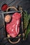 Unccoked rump steak or raw top sirloin beef meat steak. Black wooden background. Top view