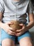 Uncertain child in blue shorts holds in his hands a young coconut with drinker