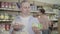 Uncertain man choosing unhealthy gingerbread cookies or healthy cabbage in grocery. Portrait of unsure male customer