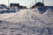 Unclean snow-covered road access to houses in  Siberian village in winter
