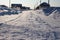 Unclean snow-covered road access to houses in a Siberian village in winter