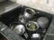 Uncleaned Aluminum and silverware kitchen utensils are kept inside the granite finishes Sink for cleaning by housewife and part of