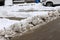 Uncleaned streets with heavy snowdrifts after snowfall in the city, cars under the snow