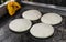 Uncooked arepas, traditional Venezuelan corn patties, at a street food market.