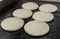 Uncooked arepas, traditional Venezuelan corn patties, at a street food market.