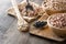 Uncooked assorted legumes in wooden bowl on wood