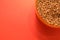 uncooked buckwheat in a plastic container on a red background