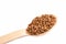 Uncooked buckwheat on wooden spoon. premium buckwheat groats on white