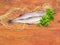 Uncooked carcasses of the hake on a wooden surface