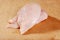Uncooked chicken breast on wooden cutting board