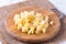 Uncooked cubical yellow potatoes on a board.