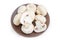 Uncooked cultivated button mushrooms on a brown dish