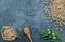 Uncooked dried chickpeas in burlap sack with raw green chickpea pod plant on rustic table