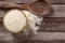 Uncooked dry Thai jasmine rice are overflow in bowl and wooden ladle isolated beside put on wood floor background.