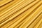 Uncooked durum fettuccine pasta background. Close up of raw spaghetti. Full frame of noodles