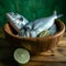 Uncooked fish with lime and herbs in a wooden bowl