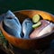 Uncooked fish with lime and herbs in a wooden bowl