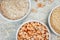 Uncooked half peas, millet and rice in white ceramic bowl on metal background macro