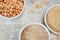 Uncooked half peas, rice and millet in white ceramic bowl above view on metal background