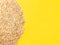 Uncooked healthy oat flakes on yellow background