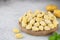 Uncooked italian potato gnocchi and cooking ingredients on wooden background. Copy space