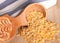 Uncooked lentil grains in wooden spoon on wooden table