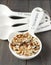 Uncooked multigrain rice in porcelain measuring spoons on wooden background