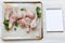 Uncooked raw chicken legs on a baking sheet paper on tray and blank notepad, overhead view. White wooden background.