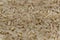 Uncooked raw long brown rice grains background, top view