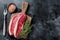 Uncooked Raw rump steak or top sirloin cap beef meat steaks on wooden board. Black background. Top view. Copy space