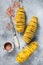 Uncooked raw Tornado or Twist potato fries. Wooden background. Top view. Copy space