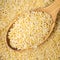 Uncooked risoni pastina in wooden spoon closeup