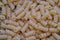 Uncooked rotini or fusilli pasta. Italian egg pasta as background