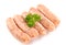 Uncooked sausages with a leaf of parsley, on white background