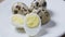Uncooked scattered quail eggs on white background top view, healthy food concept