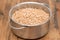 Uncooked spelt in pot on wooden background