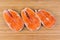 Uncooked steaks of arctic char on the wooden cutting board