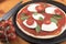 Uncooked tomato, basil and mozzarella pizza with tomatoes