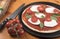 Uncooked tomato, basil and mozzarella pizza with tomatoes