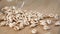 Uncooked wheat flakes scatter on a board from a glass cup in slow motion.