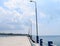 Uncrowded Ferry Jetty with Poles of Light in Open Sea and Cloudy Sky