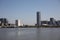 Under a blue sky, a line of modern housing buildings, towering white, stand by the riverside of huangpu River in Shanghai