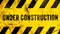 Under construction warning sign text with yellow black stripes painted on wood wall plank texture wide banner panorama background.