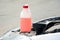 Under the open hood of the car is a white canister of pink liquid. fluid replacement.