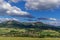 Under the sun and shadows OndÅ™ejnÃ­k and a view of other Beskydy hills and mountains with white clouds and blue sky in the