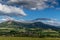 Under the sun and shadows OndÅ™ejnÃ­k and a view of other Beskydy hills and mountains with white clouds and blue sky in the